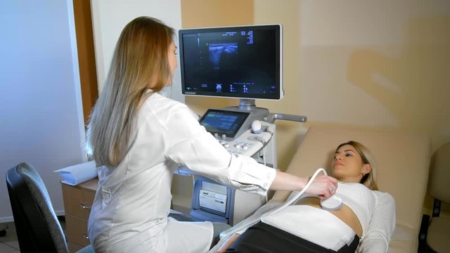 The doctor Taking A Sonogram to the patient to the woman
