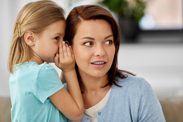 trust, gossiping and family concept - daughter whispering secret to mother at home