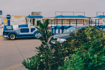 a blue steam locomotive drives through the streets of the city of Crete, entertainment for tourists