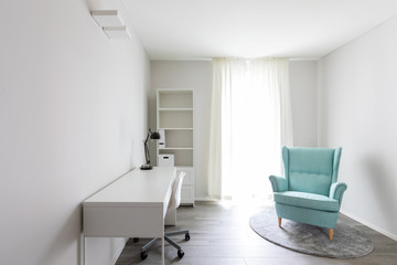 Modern room with armchair, desk and bookcase