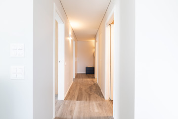 White corridor with open doors. Front view. No one inside