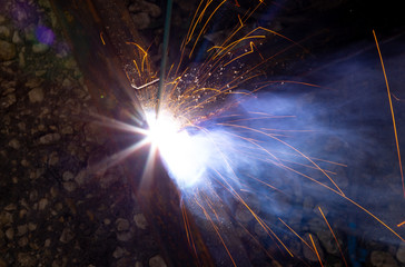 Fototapeta na wymiar Sparks from welding at a construction site as a background