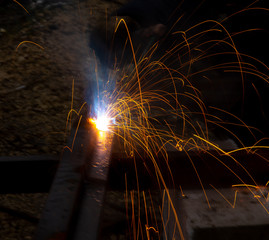 Sparks from welding at a construction site as a background