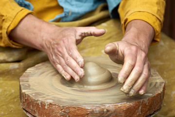 Fototapeta premium Closeup of an artisan hand making a jug of clay on a craft circle.