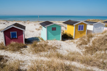 Fototapeta na wymiar Colorful beach huts with sea and clouds in background. Falsterbo, sweden
