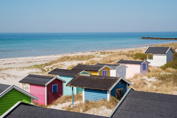 Fototapeta premium Colorful beach huts with sea and clouds in background. Falsterbo, sweden