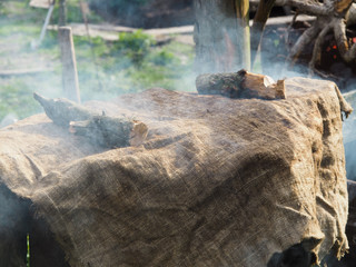 Homemade sausage made for Ukrainian Easter smokes in a rusty barrel covered with canvas.