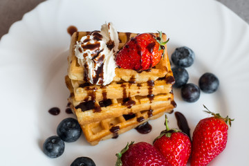  Belgian waffles with Strawberry and Blueberries on white blate close up