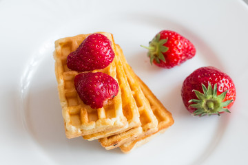 Close up of  belgian waffles with strawberries on the table 