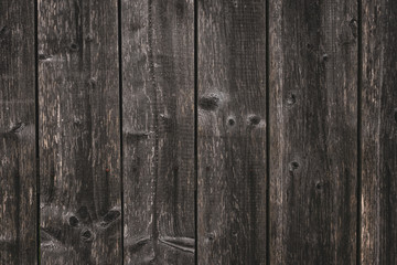 Surface of unrefined gray boards. Texture of dark grey coarse planking. Crude wooden fence. Rough...