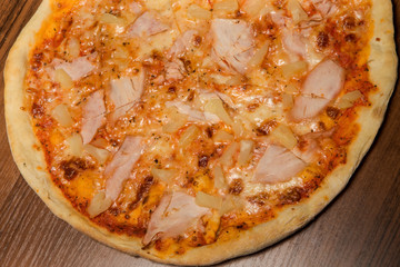 closeup sliced pizza with prosciutto and pineapple pieces
