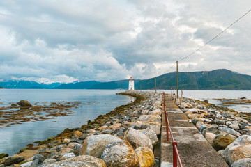 Biała latarnia morska na kamienistej skalnej wyspie o zachodzie słońca. Gofoya, Norwegia. © Tomasz
