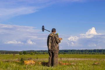 Treasure hunter in the field with a metal detector