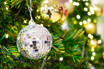 Close up. A gift hang on chrismas tree in holiday. Blurred background