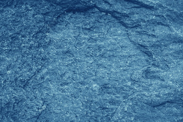 Vintage blue background. Rough painted wall of sapphire color. Imperfect plane of blue colored. Uneven old decorative toned backdrop of cyan tint. Texture of sapphirine hue. Ornamental stony surface.