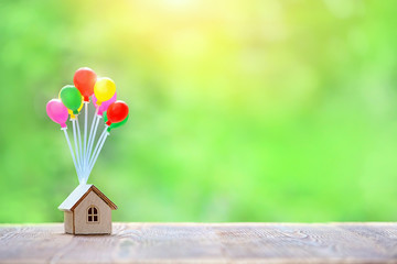 Air balloons and house on abstract nature background. Home model hanging on colorful balloons. plan...
