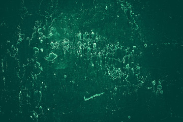 Vintage green background. Rough painted wall of emerald color. Imperfect plane of virid colored. Uneven old decorative toned backdrop of green tint. Texture of emerald hue. Ornamental stony surface.