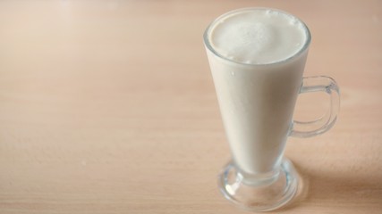 glass of milk on wooden background