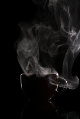 Fototapeta premium Dark cup with hot coffee and steam, isolated on black