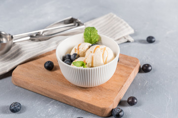 Sweet ice cream in bowl with min and blueberry