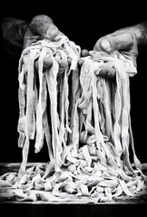 hands of man and fettuccine in black and white