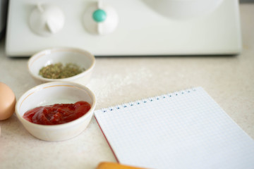 We cook a great breakfast. In the photo: sauces, flour, olive oil, wheat, butter, cheese, bread and a notebook.