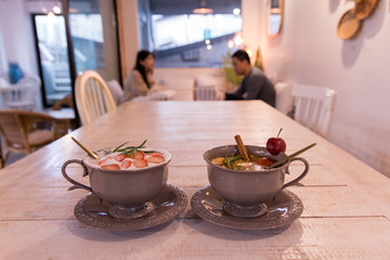 fruit flavored tea on the wooden table with blurred couple