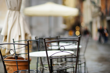 Fototapeta na wymiar Empty small outdoor restaurant tables on the main square of Lucca, Italy