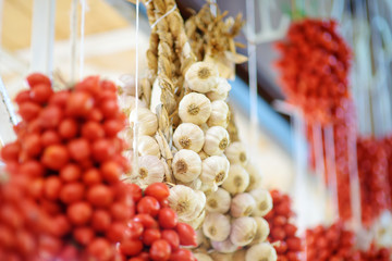 Bunches of organic garlic and cherry tomatoes sold on a marketplace in Genoa, Italy
