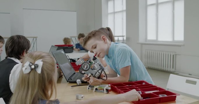 Curious kids working on a functional programable robot during robotics class at school. 4K UHD 60 FPS SLOW MOTION
