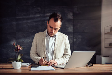 Businessman working in office and writing on a adhesive notes