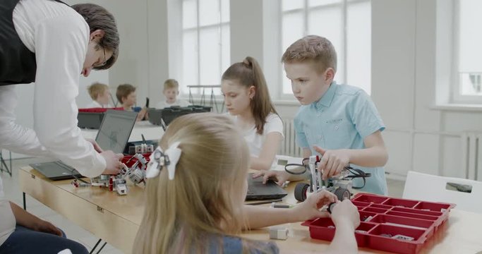 Curious kids working on a functional programable robot during robotics class at school. 4K UHD 60 FPS SLOW MOTION
