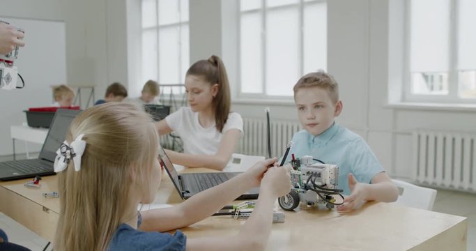 Curious kids working on a functional programable robot during robotics class at school. 4K UHD 60 FPS SLOW MOTION