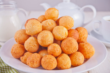 Small balls of freshly baked homemade cottage cheese doughnuts in a plate on a white background.