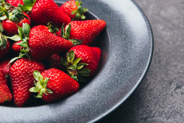 Fresh strawberries on a dark kitchen table.