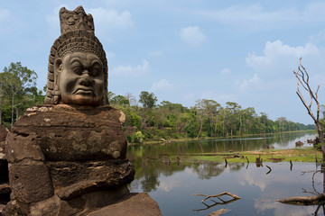 Fototapeta premium Stone carved statue of Devas on South Gate Bridge to Angkor Thom in Angkor complex, Siem Reap, Cambodia
