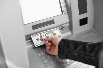 Man taking money from cash machine outdoors, closeup view