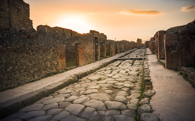Ruins of ancient city of Pompeii, ancient roman city against Vesuvius volcano at sunset, Italy. Street in Pompeii