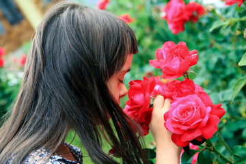 Naklejka premium Little girl speaking with flowers