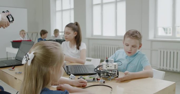 Curious kids working on a functional programable robot during robotics class at school. 4K UHD 60 FPS SLOW MOTION