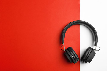 Stylish headphones on color background, top view. Space for text