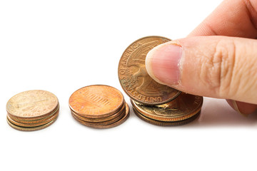 Closeup hand picking US coin from row of  coins on white background.