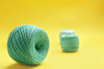 Clew of knitting threads on color background, space for text. Sewing stuff