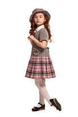 Full length shot of a lovely little kid with a long, curly hair posing isolated on white background.