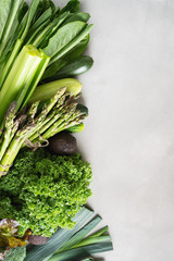 Frame of Variety of Fresh Vegetables and greenery lettuce, kale, celery, broccoli, peppers, avocado, cucumber, leek, zucchini, asparagus  on concrete background. Healthy food concept.