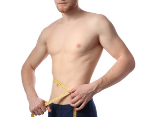 Young man with measuring tape showing his slim body on white background, closeup