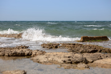 Fototapeta na wymiar Sea waves and the ruins of the ancient port