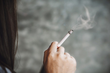 unhealthy lifestyle concept with Asian woman hand smoking cigarette