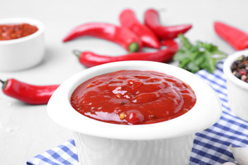 Bowl of hot chili sauce on table, closeup