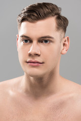 nude handsome young man looking away isolated on grey